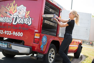 Famous Dave's BBQ team member putting food into the catering truck