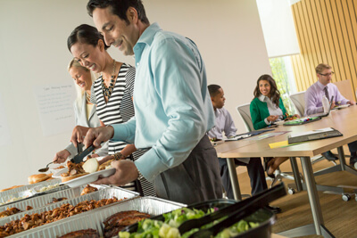 Famous Dave's BBQ Corporate Catering -woman and man grabbing Dave's BBQ at a company event